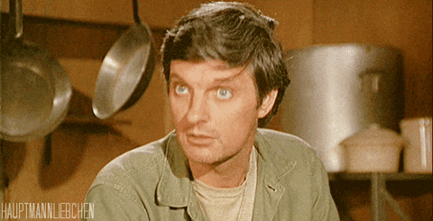 Animated GIF from the TV show MASH: a man in an army shirt in a mess tent, raising his eyebrows.